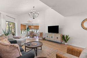 Harbour Oaks, Unit 618 في Demere Park: غرفة معيشة مع أريكة وتلفزيون