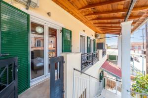 a balcony of a house with green and whiteiding at Eli Guesthouse in Kavos