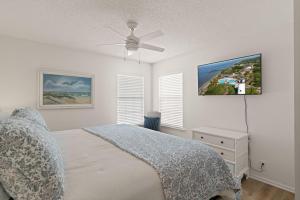 a bedroom with a bed and a ceiling fan at Point Five - 1133 Mallery St in Saint Simons Island +32 photos