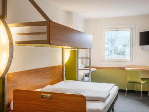 een slaapkamer met een stapelbed en een bureau bij B&B HOTEL Mainz-Süd in Mainz