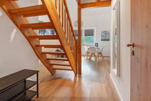 a hallway with wooden stairs and a dining room at Ferienwohnung Junge 3 in Lohe-Rickelshof