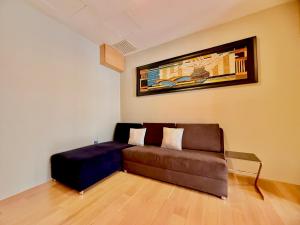 a living room with a couch and a painting on the wall at NuEmpire Subang Suite - Empire Hotel in Subang Jaya
