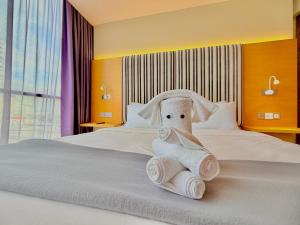 a towel animal sitting on top of a bed at NuEmpire Subang Suite - Empire Hotel in Subang Jaya