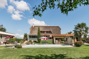 a house with a thatched roof and a swimming pool at La Clé des Chaumes - Chambre d'hôte, Bed and Breakfast avec piscine et bain nordique in Boisset-lès-Montrond