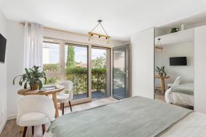 una camera da letto con un letto, un tavolo e delle sedie di La Clé des Chaumes - Chambre d'hôte, Bed and Breakfast avec piscine et bain nordique a Boisset-lès-Montrond