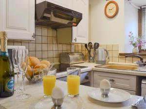 a kitchen with a counter with glasses of orange juice at Lower Barn in Wistanstow