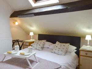 a bedroom with a white bed with a table at Lower Barn in Wistanstow