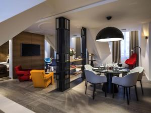 une salle à manger et un salon avec une table et des chaises dans l'établissement Grand Hôtel La Cloche Dijon - MGallery Collection, à Dijon