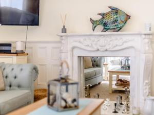 a living room with a white fireplace with a fish on the mantle at Apartment 1 - Uk32244 in Aberdyfi