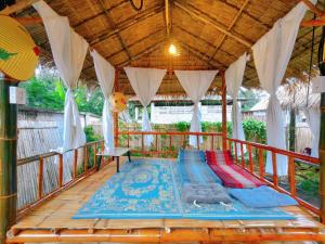 a covered porch with a bed on a wooden deck at Hug Pai Garden City Retreat in Pai