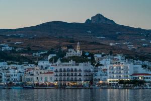 a large white building on the shore of the water at A Tinian Room 1 in Tinos Town