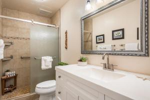a bathroom with a sink and a toilet and a mirror at Maui Sands Seaside 713 · MSS 713 Charming 1BD Near Beach in Kahana +42 photos