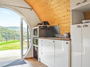 Abbey-CwmhirにあるSerenの白いキャビネットと大きな窓のあるキッチン