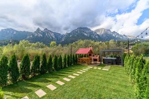 a garden with a gazebo with mountains in the background at Ama Garden Spa Apartment Busteni in Buşteni
