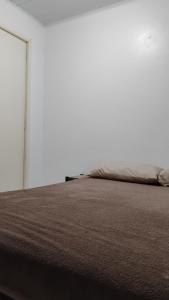 ein Bett in einem Zimmer mit einer weißen Wand in der Unterkunft Casa da Cal in Torres