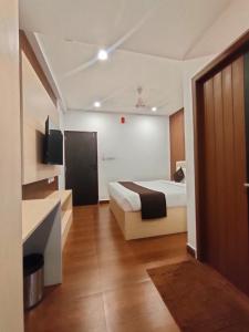a hotel room with a bed and a bathroom at Neo Elite Inn in Puducherry