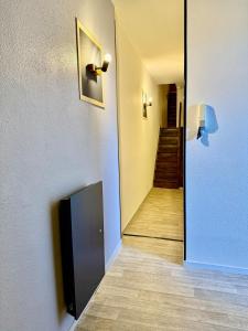 un couloir avec une télévision au mur et un couloir avec un escalier dans l'établissement Studio 2 calme Av Georges Dumas - DABNB, à Limoges 1 autre photo