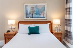 a bedroom with a bed with a blue pillow on it at The Craiglands Hotel Sure Hotel Collection by Best Western in Ilkley