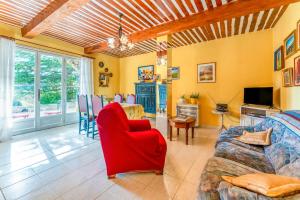 a living room with a couch and a red chair at Gîte Le Séguret in Entrechaux