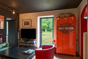 a living room with a red refrigerator and a table at Au Bout du Chemin - Vue Chateau in Vitrac
