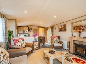 a living room with a couch and a fireplace at Woodlands in Sewerby
