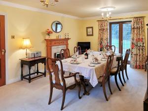 a dining room with a table and chairs and a fireplace at Holly Barn in Selattyn