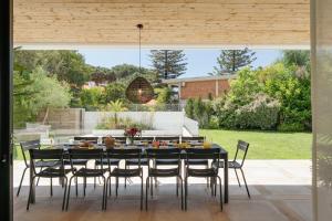 Un comedor con mesa y sillas en Cascais Contemporary Villa by Cadenzalux, en Torre