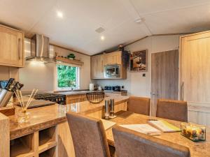 a kitchen with wooden cabinets and a table with chairs at Woodlands in Sewerby