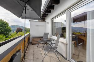 a balcony with a table and chairs and an umbrella at Auszeit Sauerland in Olsberg