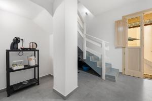 a white room with a staircase and a cabinet at Casa Vacanze Sa Domixedda in Guspini