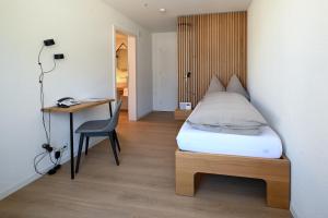 a bedroom with a bed and a desk and a chair at Hotel St. Josefshaus Engelberg in Engelberg +22 photos