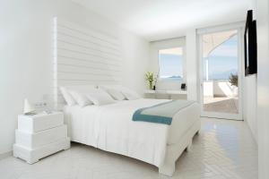 une chambre blanche avec un lit blanc et une fenêtre dans l'établissement Casa Angelina, à Praiano 63 autres photos