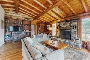 a living room with couches and a stone fireplace at Parker Lane Cabin in Weston