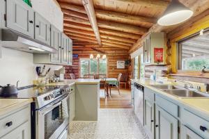 a kitchen with white cabinets and a wooden ceiling at Parker Lane Cabin in Weston