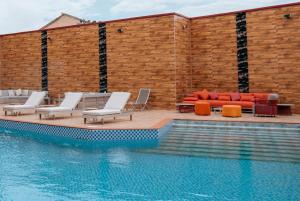 une piscine avec des chaises longues et une piscine dans l'établissement Swiss International Rancho Valeria, Warri, à Warri