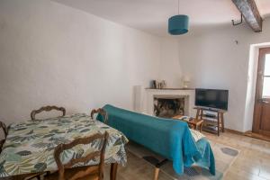 Una sala de estar con una mesa y una chimenea. en La maison de Mina, en Olmeto