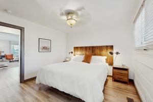 サウス・レイクタホにあるManzanita Holidayの白いベッドルーム(大型ベッド1台、鏡付)