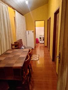 a dining room with a table and a kitchen at Casa Verde do Paulo in Santana do Riacho