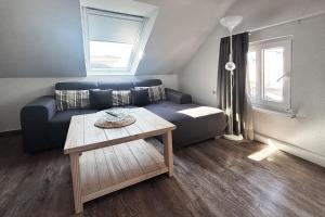 a living room with a blue couch and a table at Haus Borkumitte Appartement Freya in Borkum