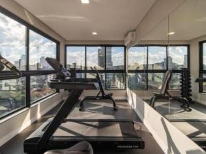 a gym with three treadmills and windows in a building at 1106 - Vila Germânica in Blumenau