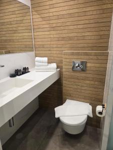 a bathroom with a white toilet and a sink at H7 TLV in Tel Aviv