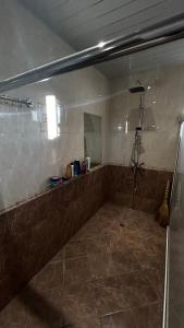 een badkamer met een douche en een tegelvloer bij Entire Villa in Karbi in Karbi