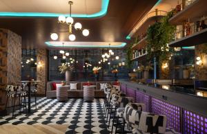 ein Restaurant mit einem karierten Boden und einer Bar in der Unterkunft NYX Hotel Rome by Leonardo Hotels in Rom