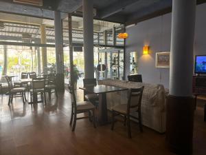 a restaurant with tables and chairs and a television at Plaza Hotel Fray Bentos in Fray Bentos
