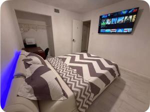a bedroom with a couch and a flat screen tv at Happy Vacation in Largo