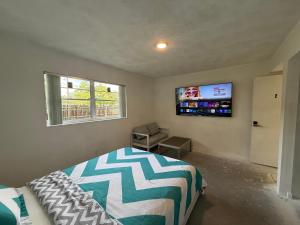 a bedroom with a bed and a flat screen tv at Happy Vacation in Largo