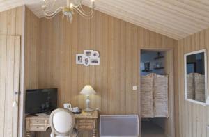 a room with a toilet and a desk with a television at Le Clos De La Combe in Saint-Jean-dʼOrbetiers