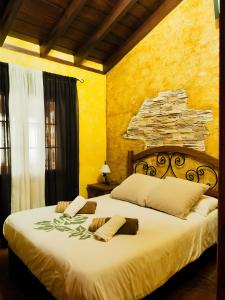 Un dormitorio con una cama grande con una pared de piedra. en Casa Cruz De Tierno, en Vallehermoso