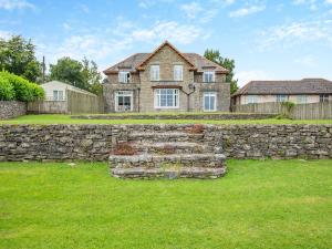 a stone wall in front of a house at Arnside Apartment in Lindale