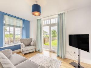 a living room with a couch and a tv at Arnside Apartment in Lindale
